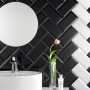 Wandfliesen Facette Metro Schwarz glänzend, 10x20 cm, im Badezimmer mit Spiegel und Waschbecken.