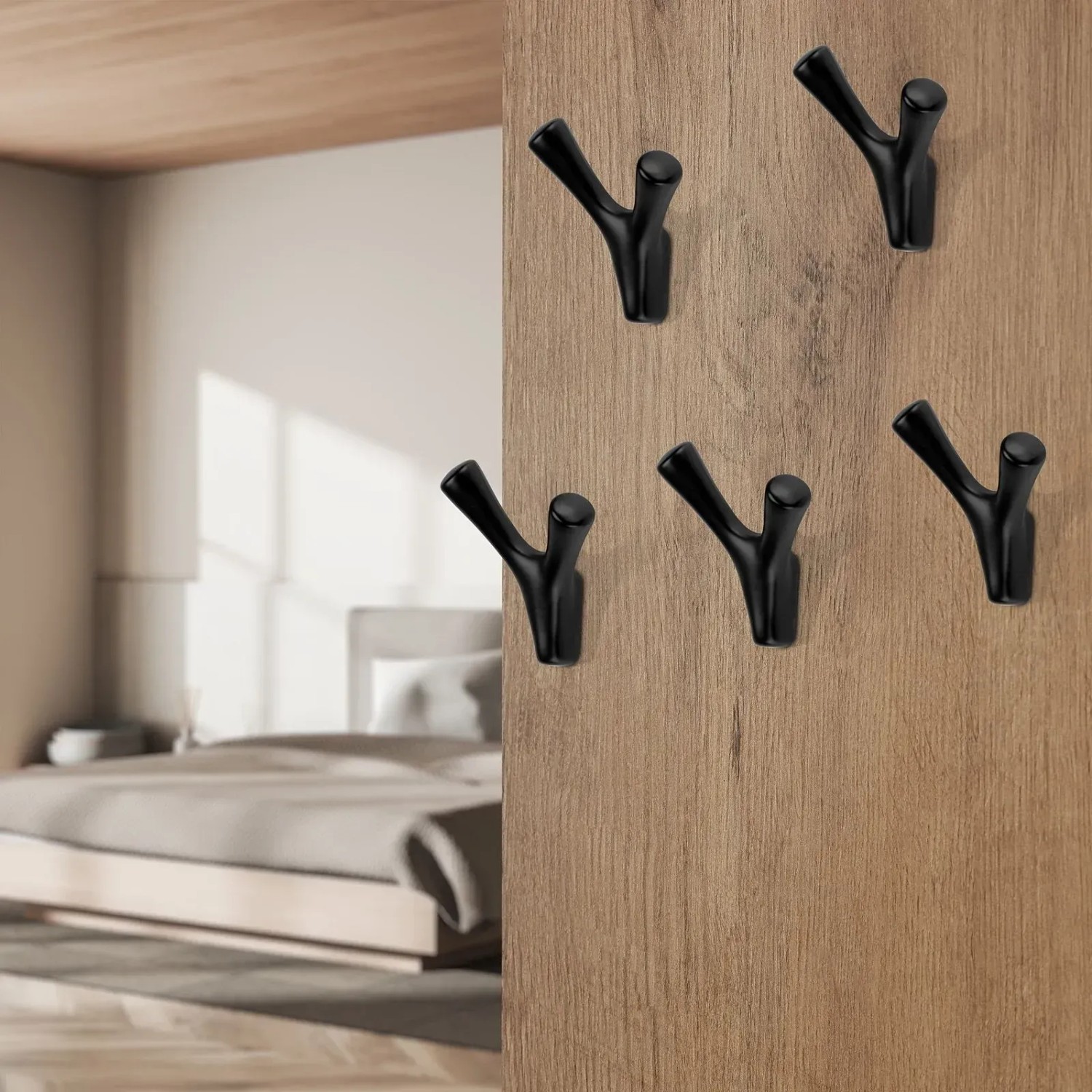 Fünf schwarze, Y-förmige Garderobenhaken auf hellem Holzpaneel. Modernes Design für Flur, Bad oder Schlafzimmer.