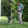 Kärcher K2 Universal Edition Hochdruckreiniger im Einsatz zur Reinigung einer Schubkarre im Garten.