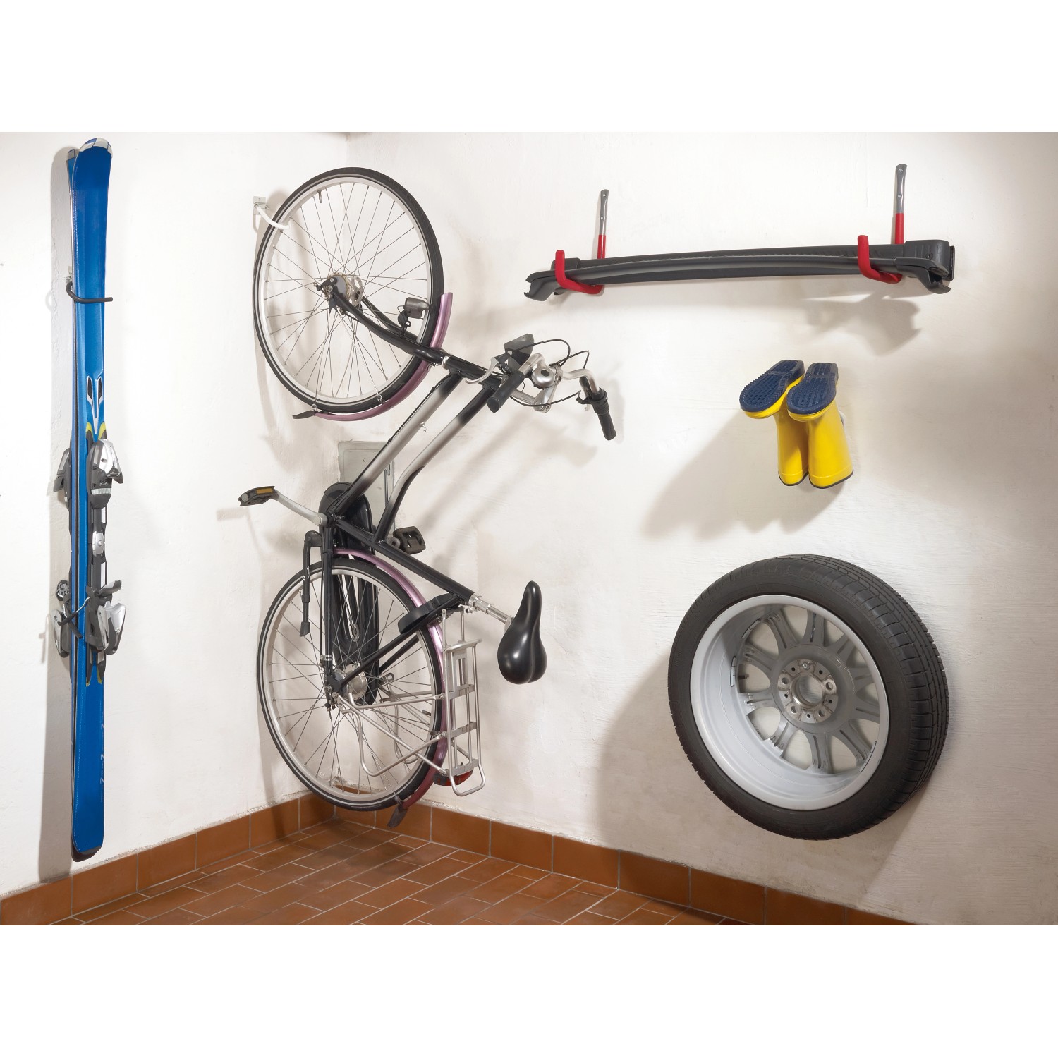 Wand mit Fahrrad, Ski, Reifen und Gummistiefel an verschiedenen Haken, inkl. verzinktem Fahrradhaken.