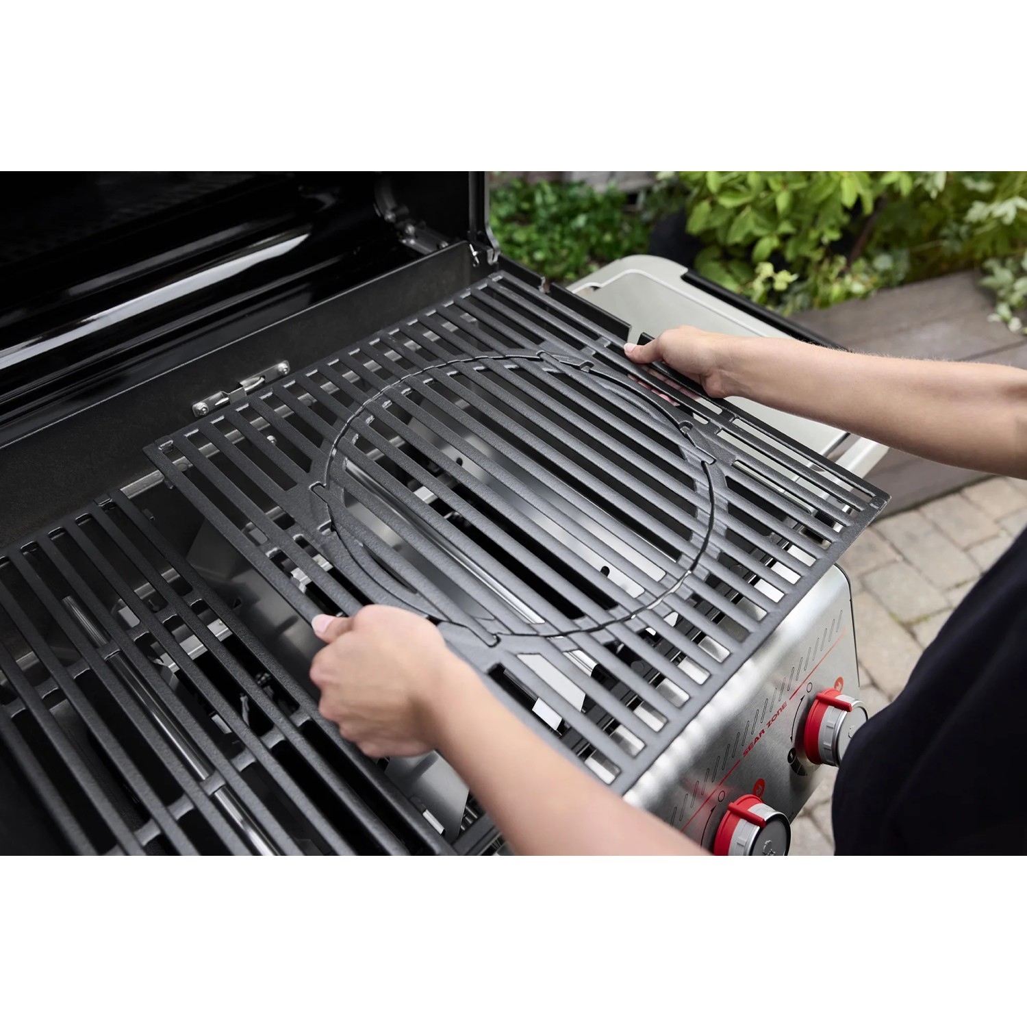 Weber Gasgrill E-325: Person setzt Crafted Grillrost ein. Grill aus der Kategorie Gasgrills.