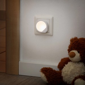 Briloner Steckdosenlicht Quiri, warmweißes Nachtlicht für die Steckdose, neben Teddybär.