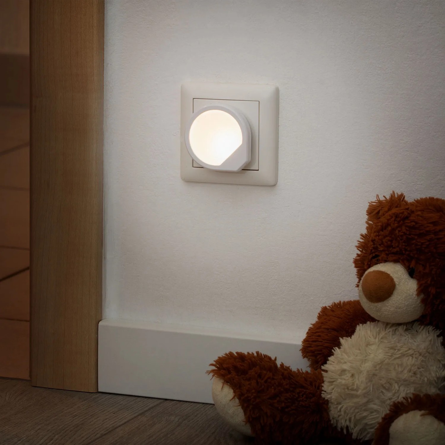 Briloner Steckdosenlicht Quiri, warmweißes Nachtlicht für die Steckdose, neben Teddybär.