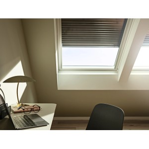 Velux Solar-Rollladen SSL CK02, dunkelgrau, teilweise geöffnet am Dachfenster im Dachgeschoss.