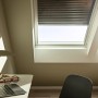 Velux Solar-Rollladen SSL CK02, dunkelgrau, teilweise geöffnet am Dachfenster im Dachgeschoss.