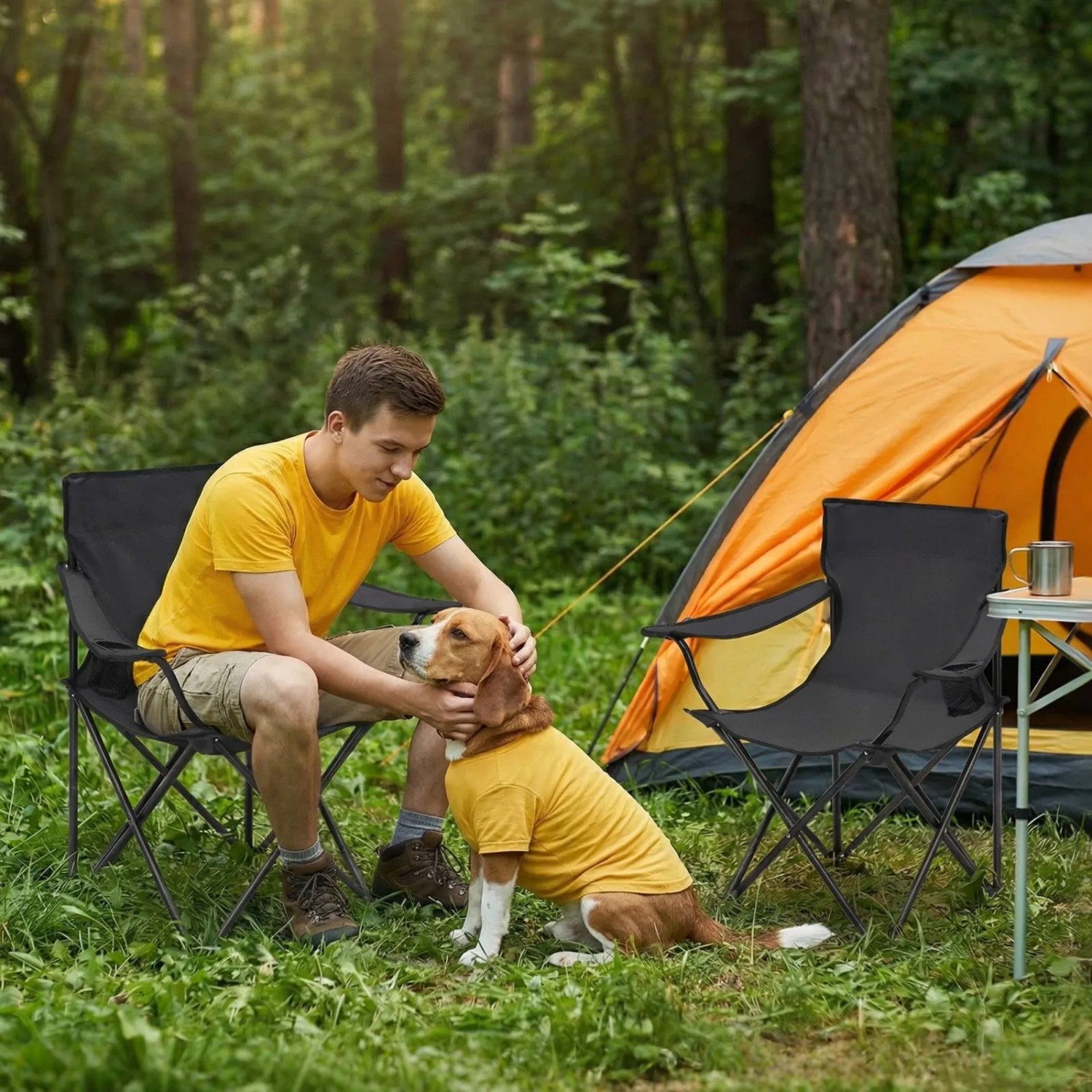 Mann und Hund sitzen auf Sunula Campingstühlen vor einem Zelt. Faltbarer Anglerstuhl mit Getränkehalter.