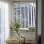 Weiß gestreifter Lamellenvorhang (Set) vor Fenster, für Lichtregulierung und Sichtschutz.