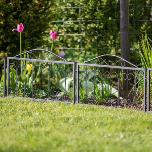 Schwarzer Relaxdays Beetzaun aus Metall (4er Set) mit Erdspießen im Garten.