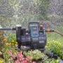 Gardena smart Haus- und Gartenautomat 5000-5 im Einsatz, bewässert Garten mit Blumen.