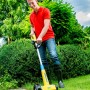 Mann nutzt Gloria Kantenschneider Cut&Brush 2-in-1 zur Rasenkantenpflege im Garten.