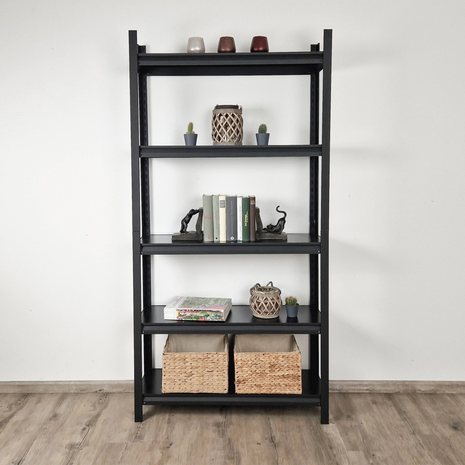 Schwarzes TRUTZHOLM Wohnzimmerregal (180x90x30cm) mit fünf Regalböden und Deko.