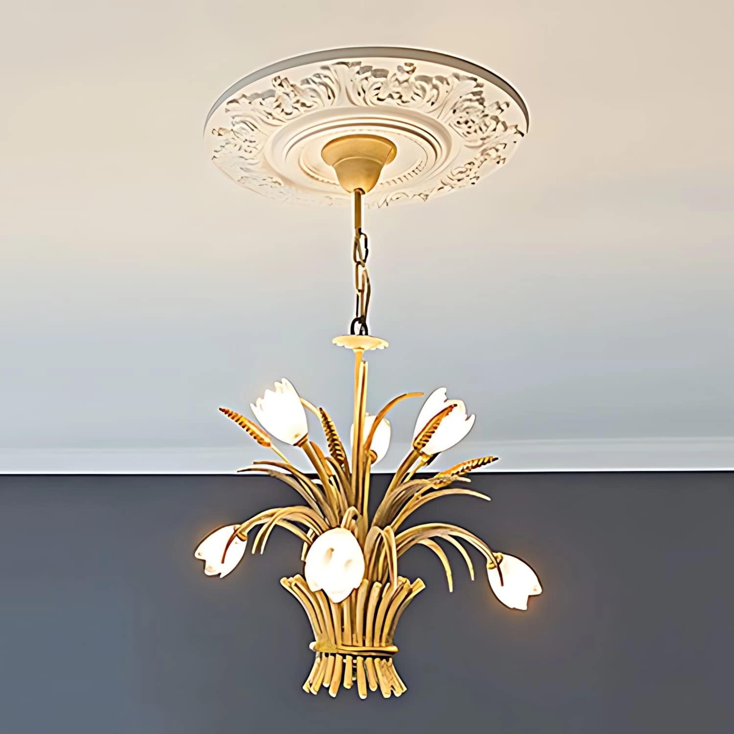 Weiße PROFHOME Deckenrosette (Ø 47cm) aus Polyurethan als Zierelement unter einer Lampe.