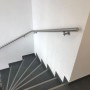 Edelstahl Handlauf mit Rundstabkonsole und Wandhalterung (75mm) an einer Treppe.
