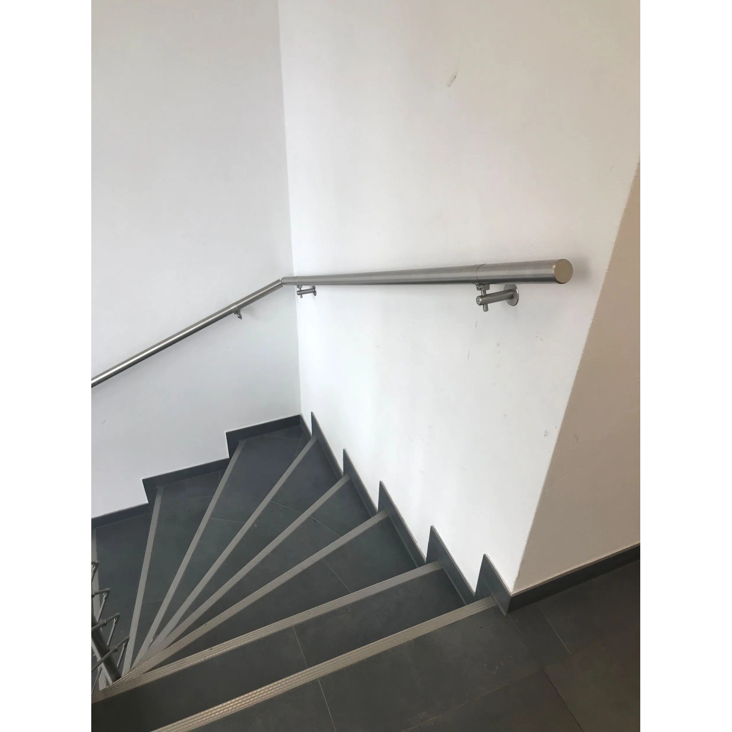 Edelstahl Handlauf mit Rundstabkonsole und Wandhalterung (75mm) an einer Treppe.