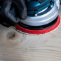 Bosch Expert Netzschleifblatt-Set beim Schleifen von Holz mit Exzenterschleifer.