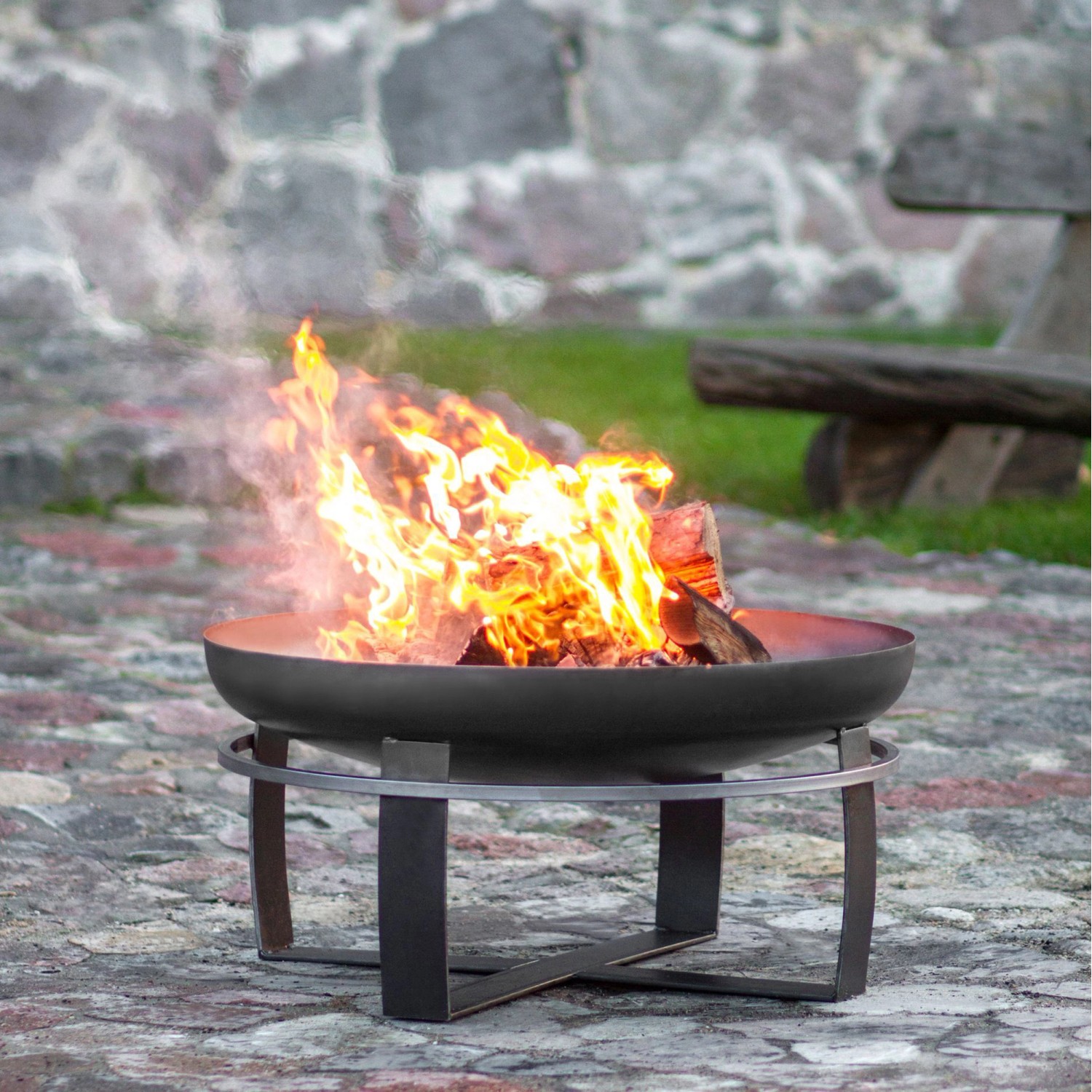 Wilk Feuerschale Viking, Ø 60cm, aus Stahl mit Feuer und Holzscheiten im Garten.