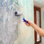 Auftragen der Knauf Rotband Universalgrundierung mit Farbroller auf eine Wand.
