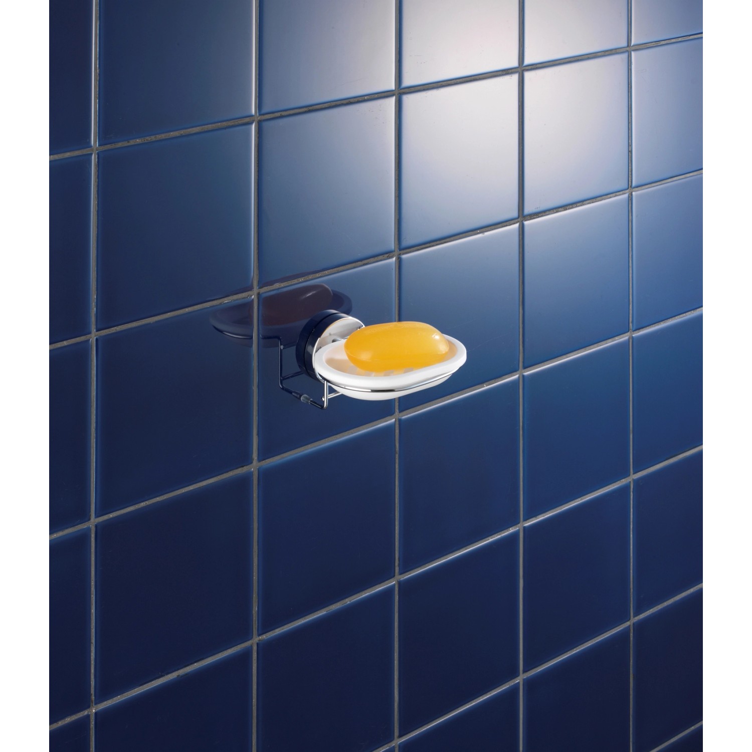 Wenko Vacuum-Loc Seifenablage Milazzo, Chrom/Weiß mit Seife an blauer Wand.