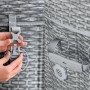 Hände schließen grauen Clipverschluss an der Rattan-Abdeckung des Bestway Bali AirJet Whirlpools. Sichere Befestigung.