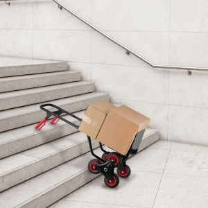Schwarze Stahl Sackkarre Treppensteiger mit 6 Rädern und roten Akzenten, beladen mit Kartons auf einer Betontreppe.