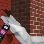 Anwendung von MEM Dicht-Fix-Spray zur Abdichtung eines Schornsteins auf einem Dach.