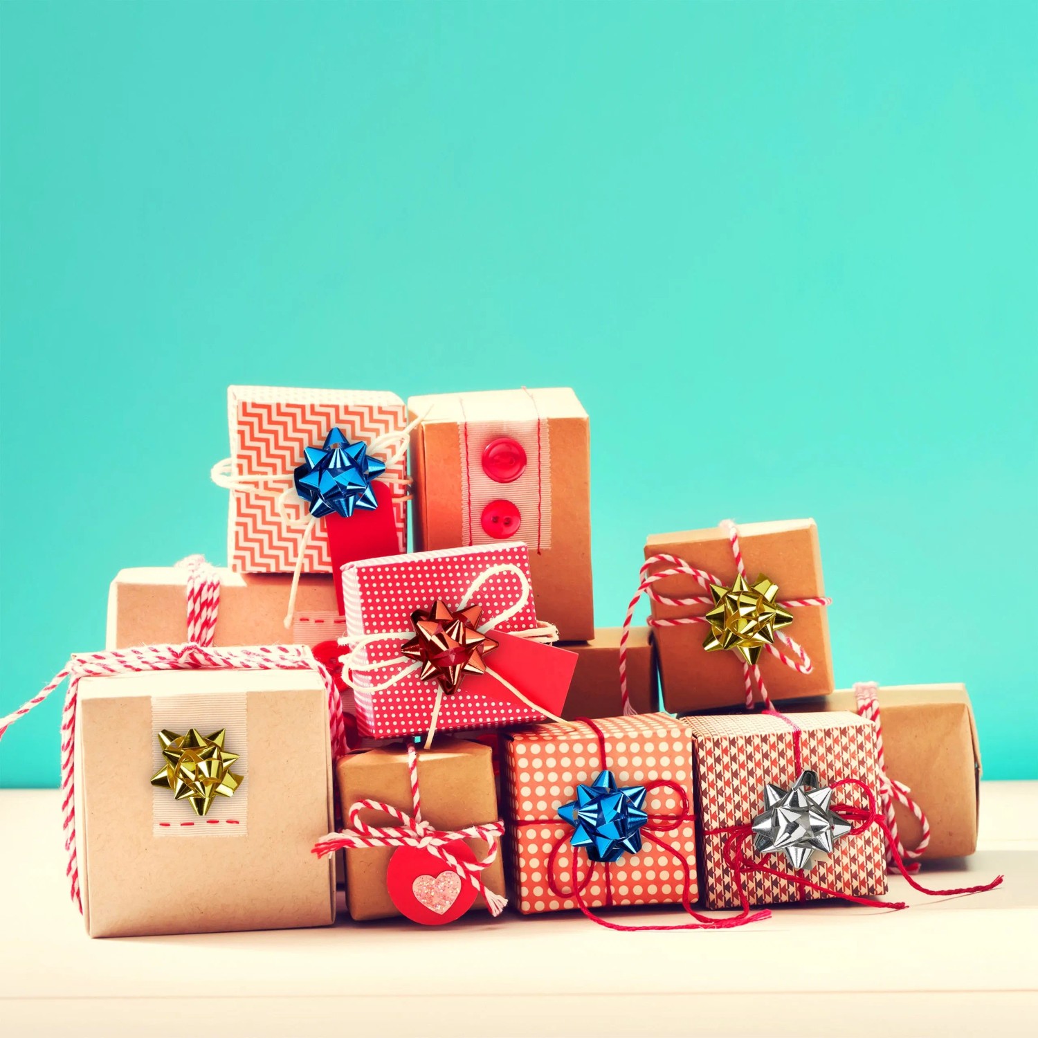 Bunte, glänzende Dekoschleifen auf festlich verpackten Geschenken. Ideal für Weihnachten und Geburtstage.