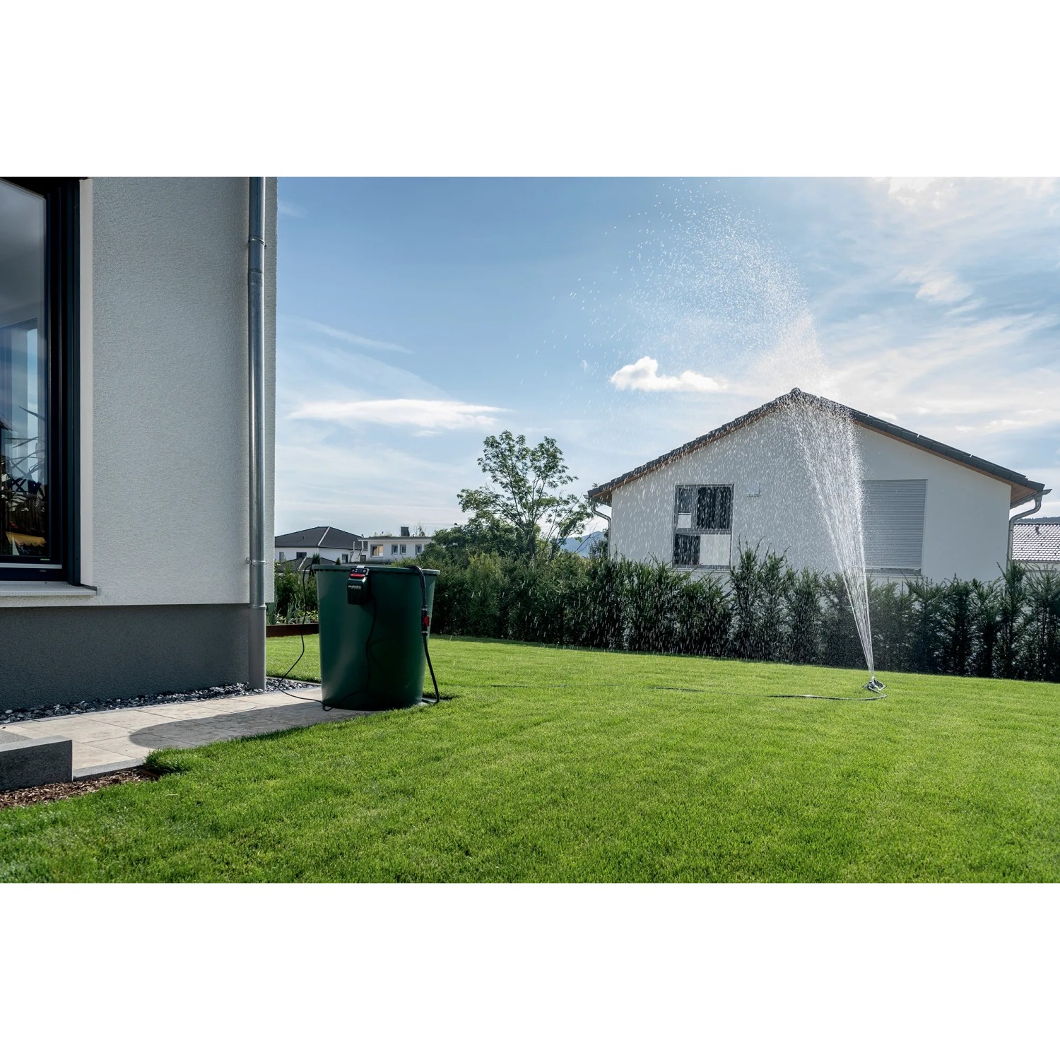 Metabo Akku-Tauchpumpe TPF 18 LTX 2200 beim Bewässern eines Gartens mit Rasensprenger.