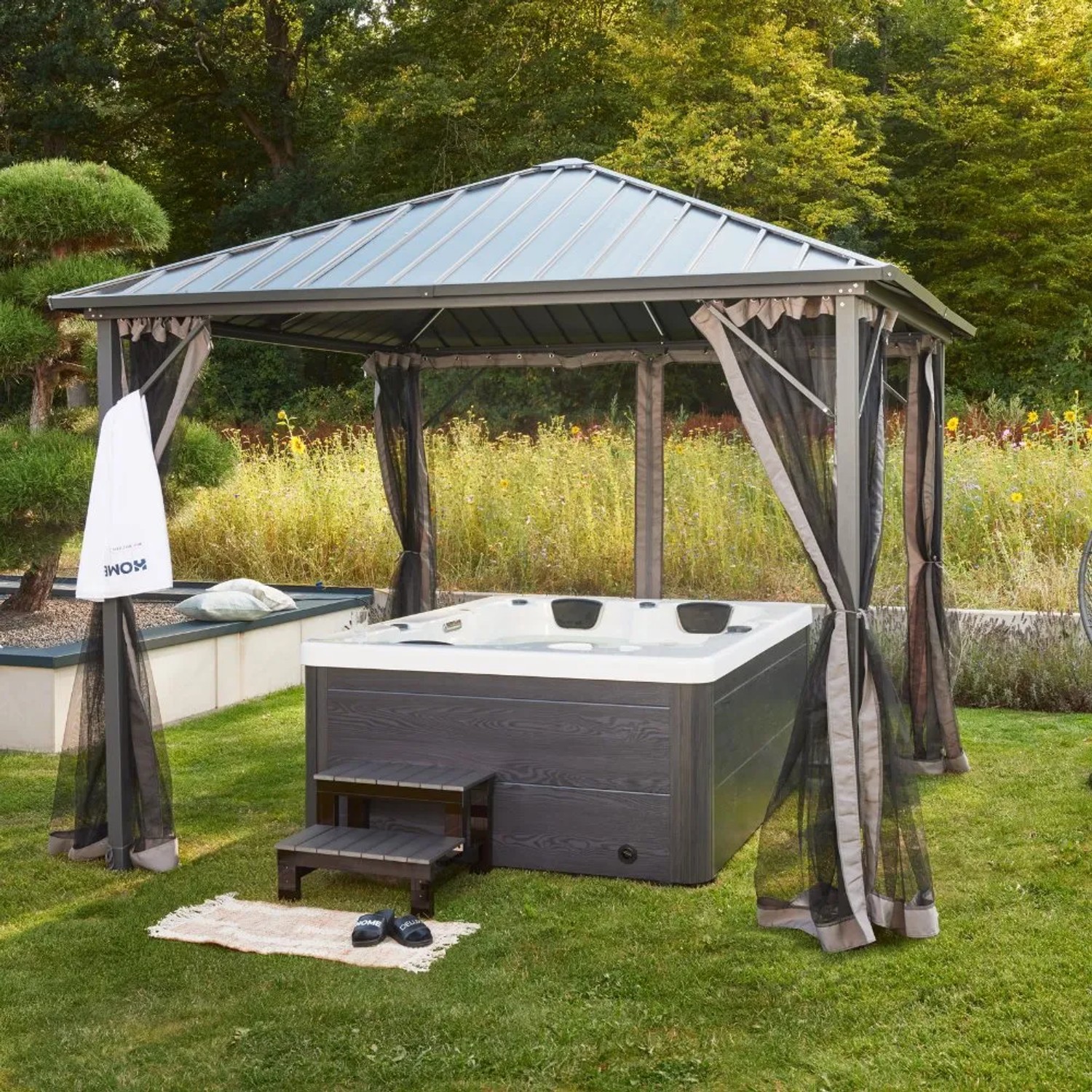Home Deluxe Outdoor Whirlpool White Marble Plus mit Treppe und Thermoabdeckung im Garten.