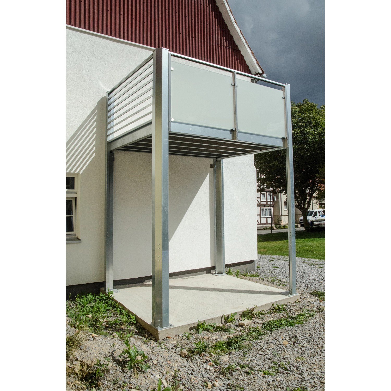 Designbalkon Small mit Holzfußboden und Lamellengeländer am Haus.