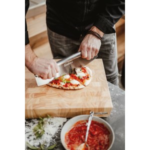 Enders Pizzaschneider aus Edelstahl schneidet Pizza auf Holzbrett. Grillutensil für perfekte Pizzastücke.