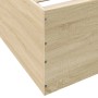 Sonoma-Eiche Bettgestell aus Holzwerkstoff. Detail der Ecke mit heller Holzmaserung und sichtbaren Schrauben.