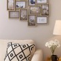 Kobolo Mehrfachbilderrahmen aus Holz, grau/natur, für 12 Fotos, an der Wand über einem Sofa.