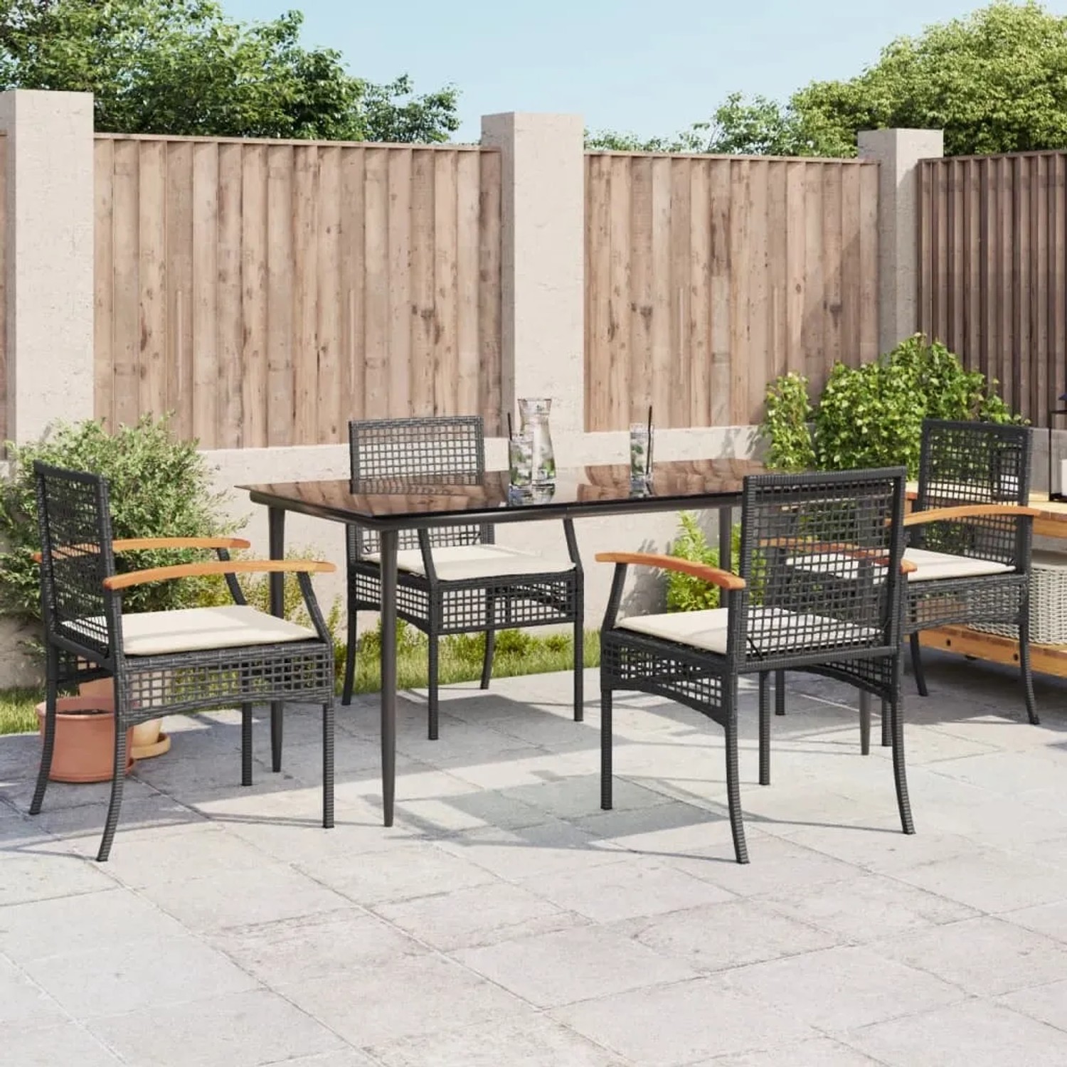 Schwarze 5-tlg. Garten-Essgruppe aus Polyrattan mit Tisch und Stühlen inklusive cremefarbener Kissen.