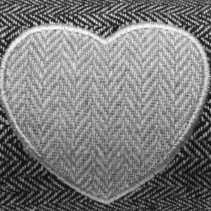 Detailaufnahme: Anthrazitfarbener Beautissu Zugluftstopper mit Herzapplikation.