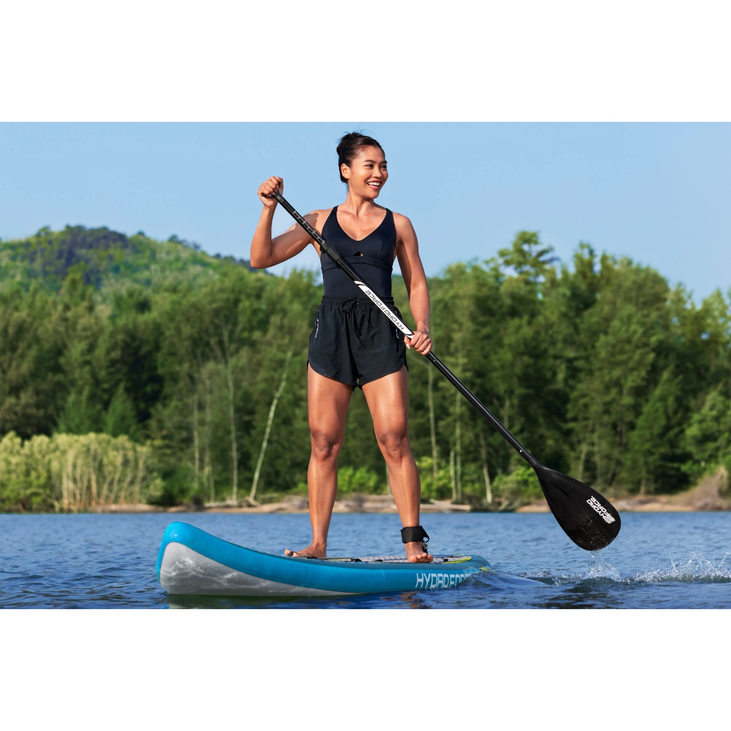 Frau auf Bestway SUP Aqua Glider Board mit Paddel auf dem Wasser.