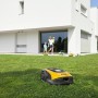 Gelb-schwarzer Stiga Mähroboter G 600 auf Rasen vor modernem Haus mit Familie.