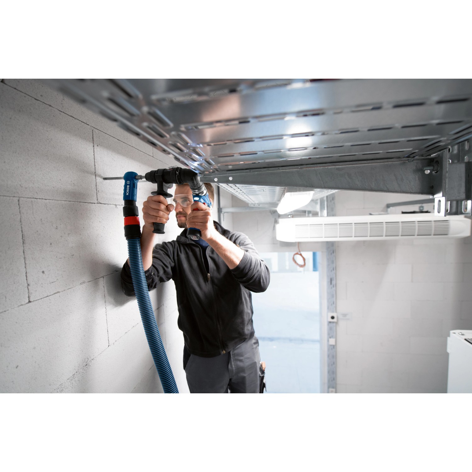 Handwerker bohrt mit Bosch Professional Bohrhammeraufsatz GFA 12-H FlexiClick in Decke.