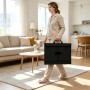 Frau trägt schwarzen Relaxdays Puzzlekoffer aus Polyester mit Tragegriff im Wohnzimmer. Ideal für Puzzle Aufbewahrung & Transport.