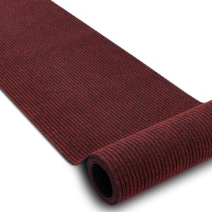 Rote, gerippte RugsX Türmatte aus Polypropylen, rutschfest, teilweise aufgerollt. Ideal für Innen- und Außenbereich.