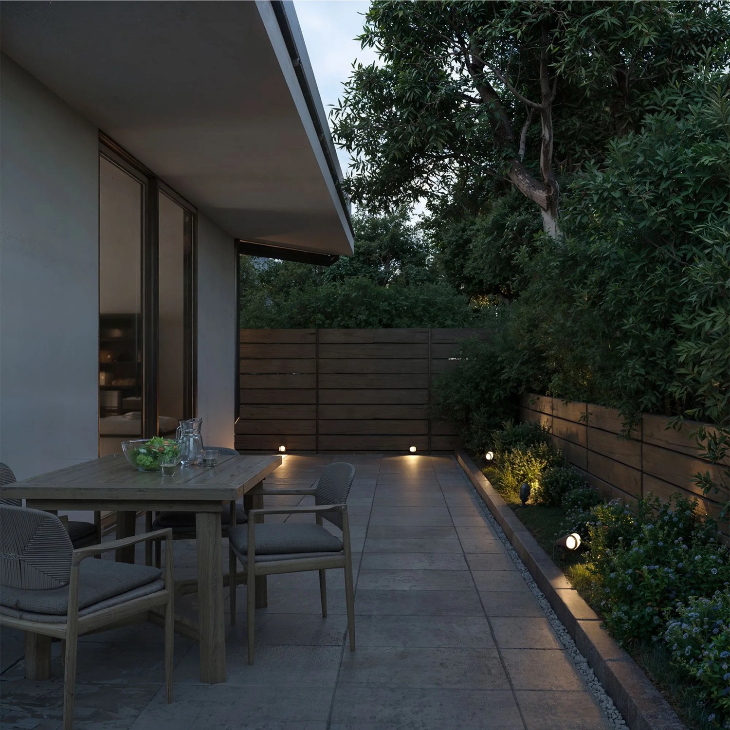Philips Cylr Erdspießleuchte, schwarz, im Garten mit Terrasse und Gartenstrahler.