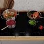 Schwarzes Respekta Induktionskochfeld Fynn 77 cm mit Töpfen und Speisen.