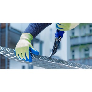 Hände mit LUX Schnittschutz-Handschuhen Gr. 10 schneiden Metall mit einer Schere.