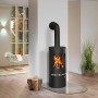 Schwarzer Justus Kaminofen Faro 2.0 mit Holz auf Glasboden im Wohnraum.