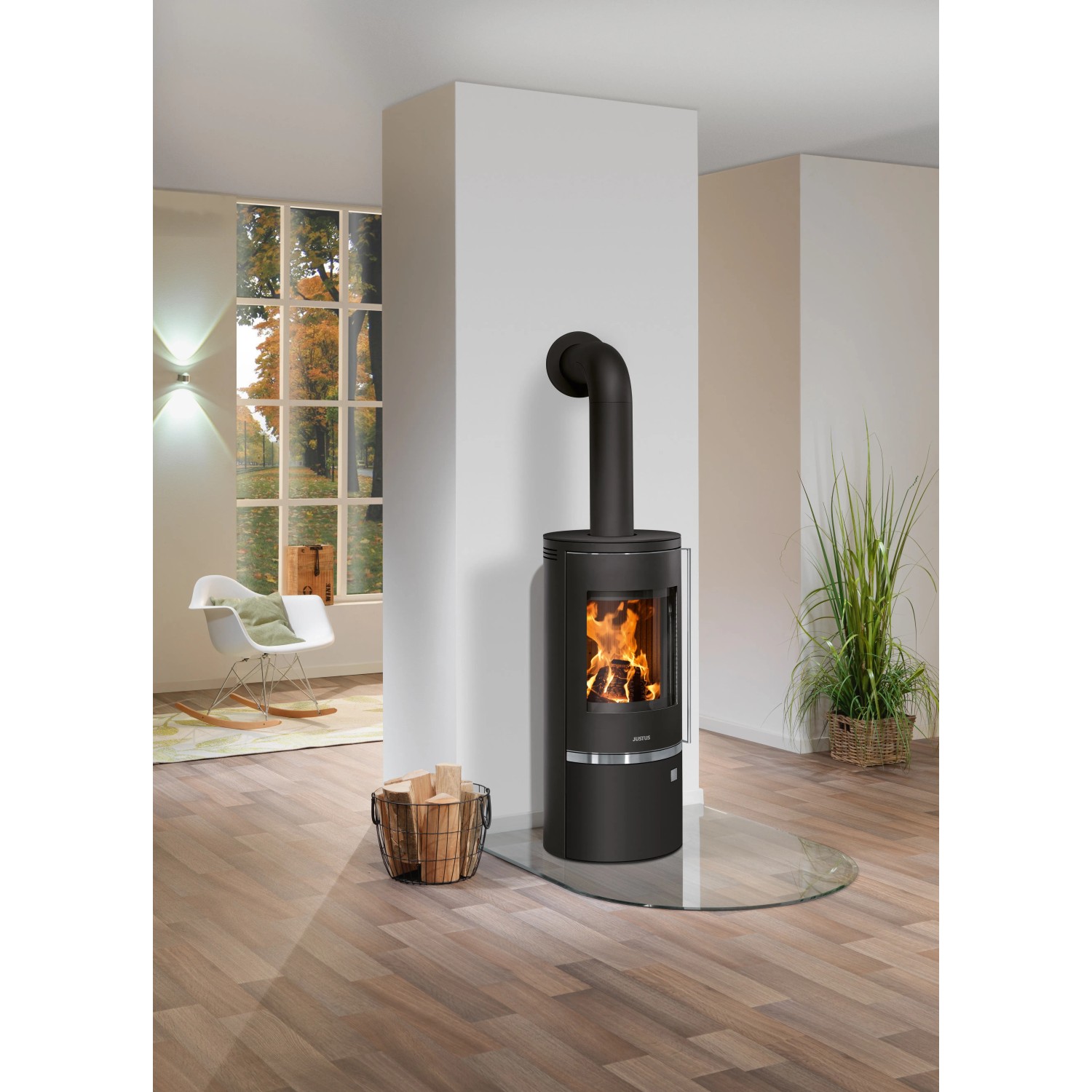 Schwarzer Justus Kaminofen Faro 2.0 mit Holz auf Glasboden im Wohnraum.