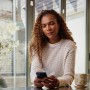 Frau nutzt die Yale Home App auf ihrem Smartphone, um die Alarmanlage zu steuern.