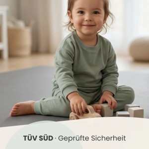 Kind spielt auf LittleTom Puzzlematte, 18-teilig, grau, mit Holzspielzeug.