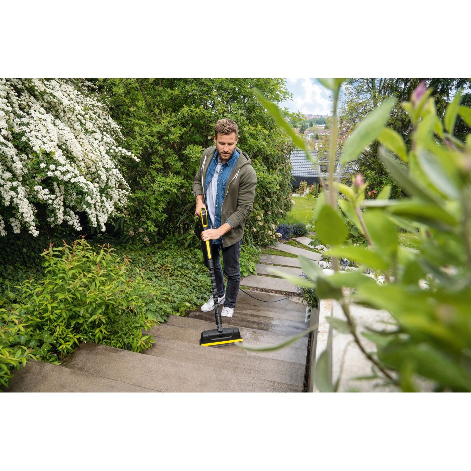 Mann reinigt Treppe mit Kärcher Flächenreiniger Powerschrubber PS 30.