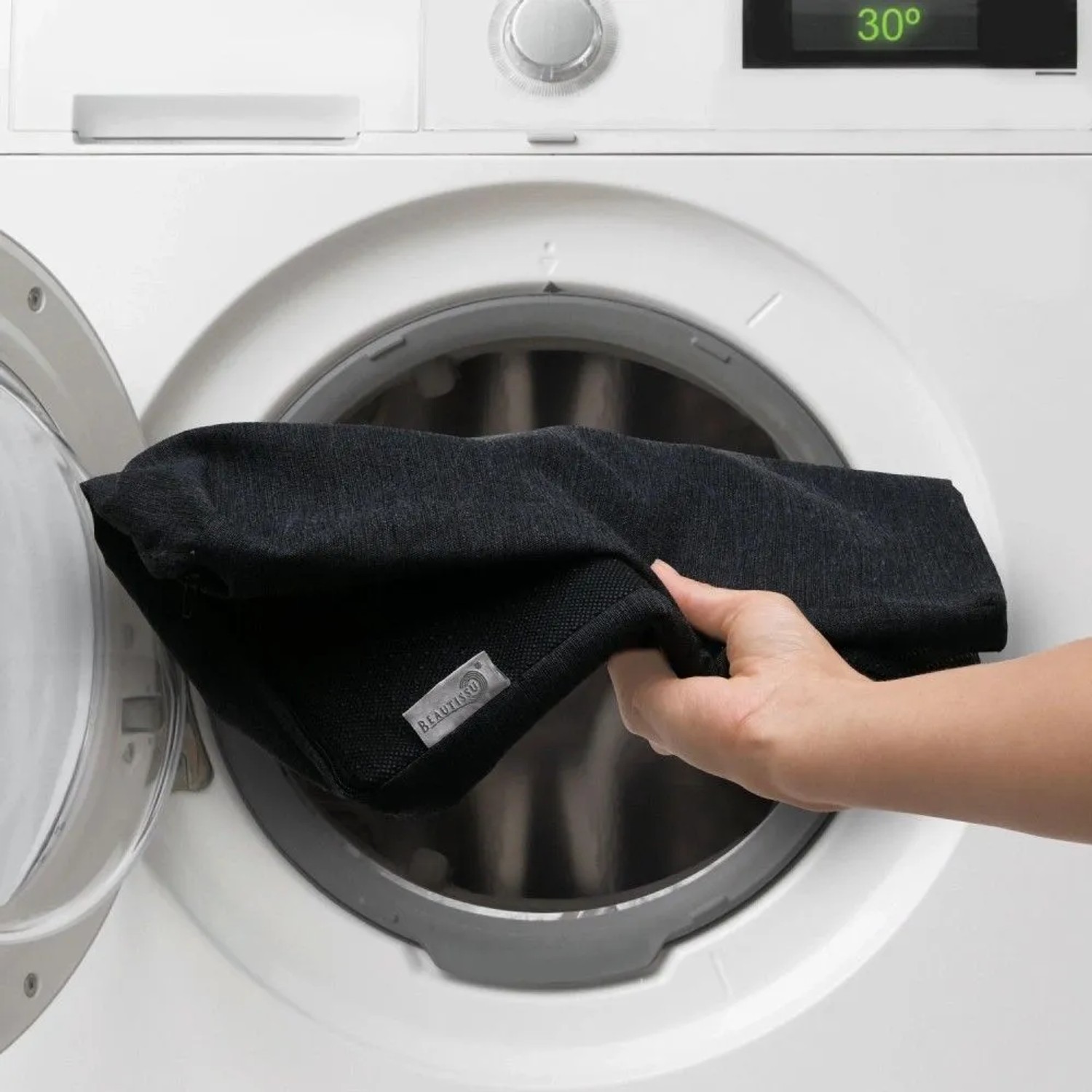 Hand legt anthrazit Beautissu Sitzkeilkissen Bezug in Waschmaschine. 30°C Anzeige. Bezug waschbar für Hygiene.