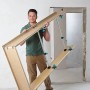 Mann trägt Wolfcraft Türfutterstrebe Easy zum Einbau. Spannwerkzeug für Türzargen.