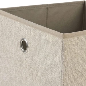 Beige Stoffbox mit strukturierter Oberfläche und silberner Metallöse. Faltbare Aufbewahrungsbox für Regale.